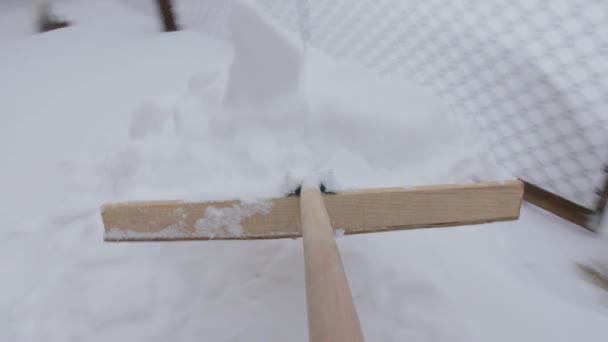 Αφαίρεση χιονιού στην πίσω αυλή με ξύλινο φτυάρι. — Αρχείο Βίντεο