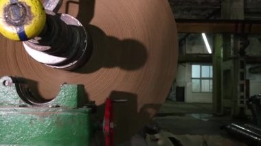 Üretim vinci büyük bir rulo kağıt kaldırır..