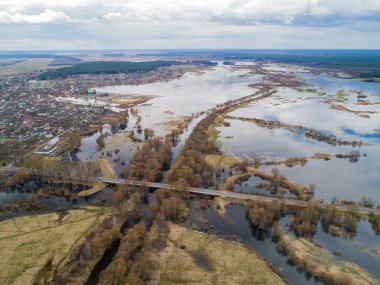 Nehirde bahar seli. Köprü, yol, arabalar, kırsal bölge. Bahar.