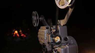 Sokakta çalışan bir retro sinema projektörü. Filmin dönen bobinleri.