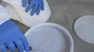 Bir inşaat işçisinin eli, tamir için sıvı bir spatula tutar..