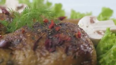 Mantar ve marulla süslenmiş bir tabakta kızarmış tavuk butları..