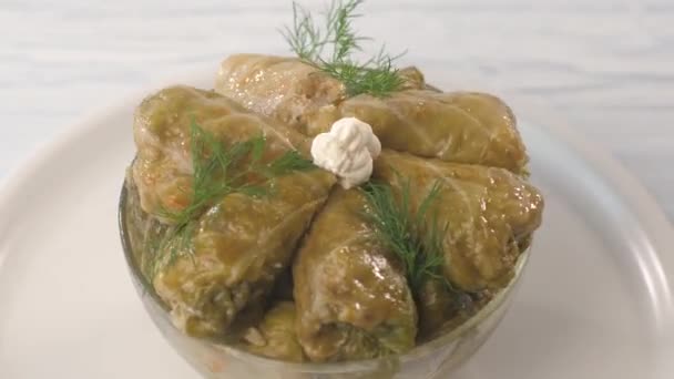 Prepared triangular stuffed cabbage, decorated with dill and sour cream. — Stock Video