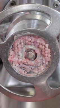 Dikey video. Kıymalı et yavaş yavaş elektrik mekanizmasından çıkar ve özel tabağa düşer. Kıyma makinesi malzemeleri işler ve uygun gıda üretimi için son parçaları yaratır.