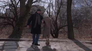 Son sınıfların mutlu çifti bahar parkında dirseklerini birleştiriyor. Mutlu olgun kadın ve erkek, aşk ilişkisinin mutluluğunu şehir sokaklarında paylaşarak dans ediyor. Evlilik yıldönümü