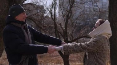 Mutlu yaşlı kadın ve erkek bahar parkında çıplak ağaçlara karşı dans ediyor. Romantik olgun çift dışarıda müzik dinleyerek evlilik yıldönümünü kutluyor. Sağlıklı aktivite ve yaşam tarzı