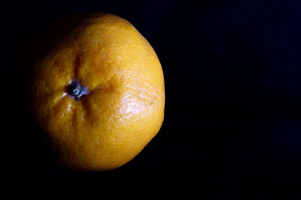 Mandarina sobre fondo negro oscuro —  Fotos de Stock