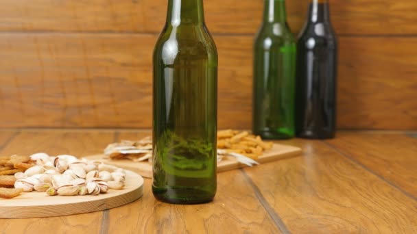 Composition of beer, crackers, pistachios, dried fish. A hand puts beer — Stock Video