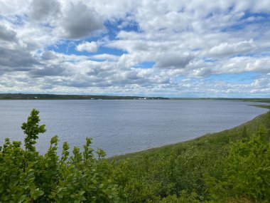 Taimyr tundrasında bir gölün üzerinde kar beyazı bulutlar.