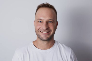 Beyaz arka planda gülümseyen bir adam