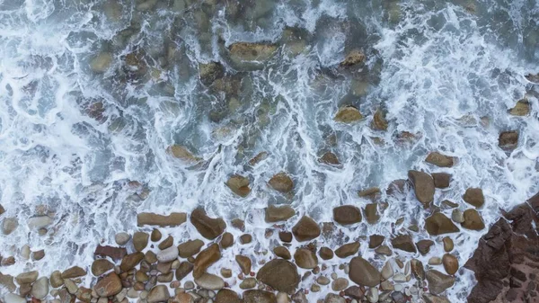 A waves in stones beach, closeup vertical view