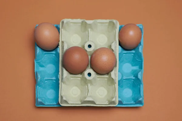 Eggs in an egg carton with orange background, minimalism