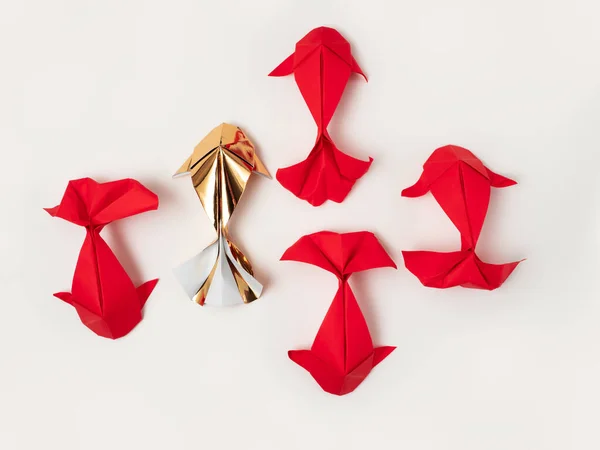 Kırmızı ve altın sarısı origami koi sazan balığı, krem arkaplanda balık avlar. Yukardan aşağıya düz