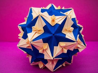 Mavi ve krema desenli Kusudama origami topu parlak pembe arka planda