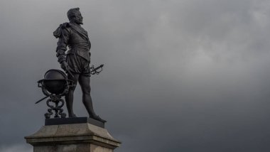 PLYMOUTH, DEVON, İngiltere - Mart 06 2020: Sir Francis Drake heykeli fırtına bulutları ile Hoe 'ya bakıyor