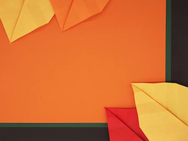 Kağıt origami yaprakları sonbahar temalı kağıt arka planda balkabağı, koyu yeşil ve çikolata kahverengisi