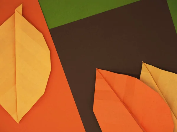 Kağıt origami yaprakları sonbahar temalı kağıtta kehribar, yaprak yeşili ve kestane rengi kahverengi arka plan