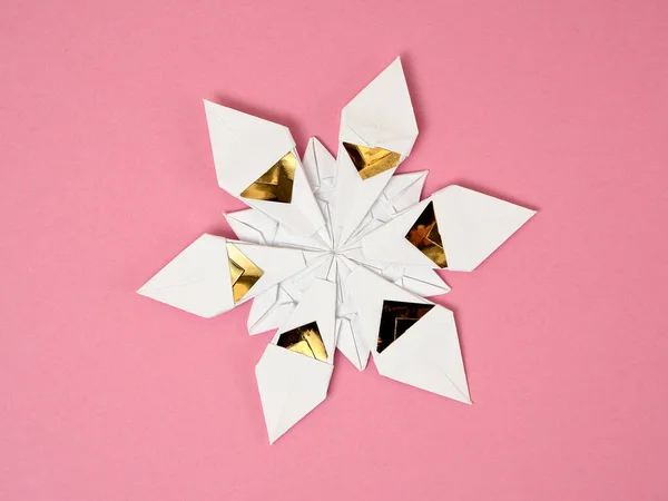 Beyaz ve altın folyo kağıda sarılı tek bir origami yıldızı.