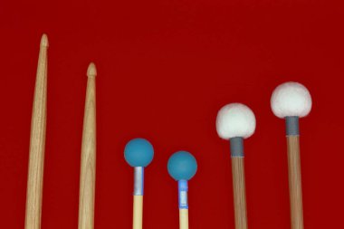 Kırmızı arkaplanda perküsyon sopaları.