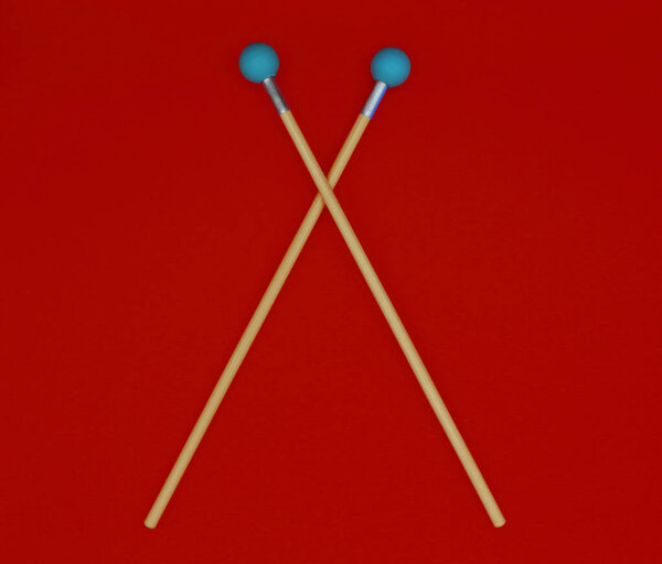 Crossed xylophone mallets on a red background.