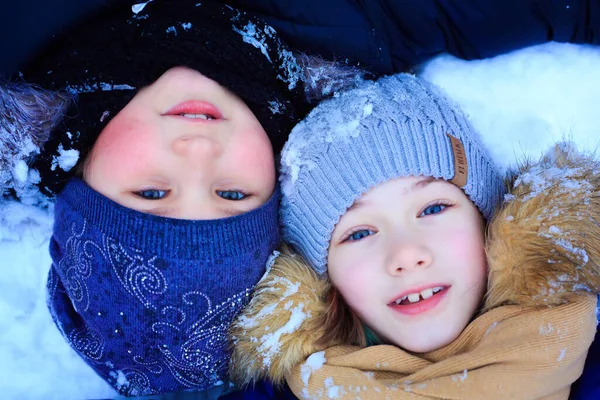 Le bambine giocano nella neve, gettano neve, cadono, si divertono, parlano e comunicano — Foto Stock