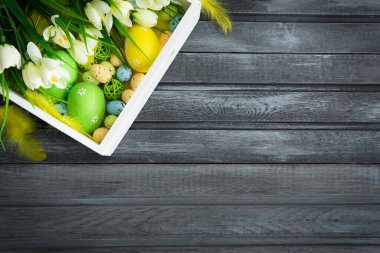 Tahtada çiçekler olan Paskalya yumurtaları, Paskalya bayramı konsepti. Metin için alanı kopyala.