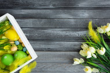 Tahtada çiçekler olan Paskalya yumurtaları, Paskalya bayramı konsepti. Metin için alanı kopyala.