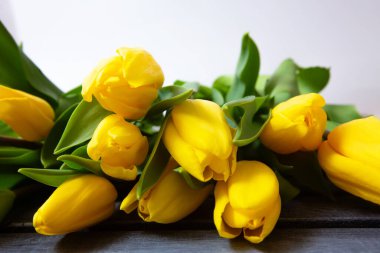 Taze sarı laleler ahşap masa arkaplanının üzerinde fotokopi alanı ile birlikte.