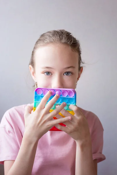 Adolescent fille jouer avec ronde silicone coloré anti stress pop il jouet. Poussez Pop Bubble dans les mains. Gros plan. — Photo