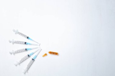 Deri altı enjeksiyonu. Mavi iğneli şırıngalar ve kırık kahverengi ampul. Tıbbi Enjektörler. Yüksek kalite fotoğraf