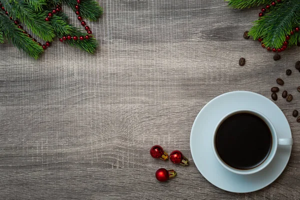 Filiżanka kawy z dekoracjami świątecznymi na drewnianym stole — Zdjęcie stockowe