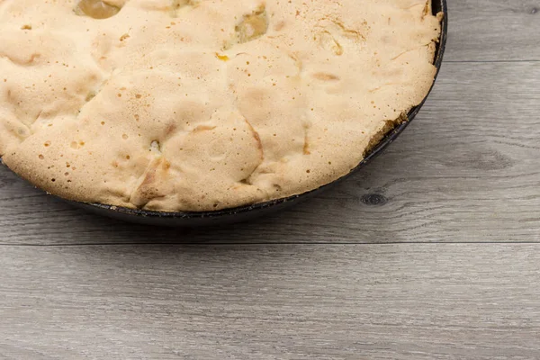 Sponge cake with  apples in a cast-iron pan, homemade, fragment close-up