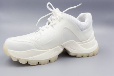 Gri arka planda beyaz spor ayakkabılar.