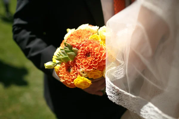 Bride and groom holding colorful bouquet — Stock Photo, Image