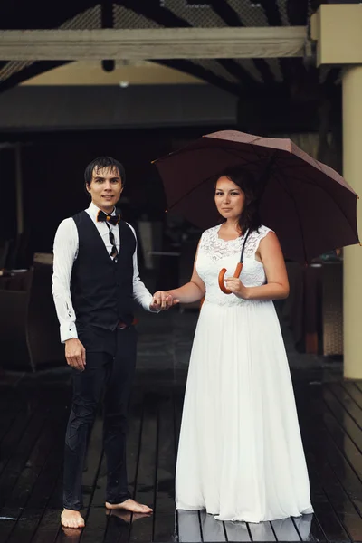 Sposa con ombrello e sposo — Foto Stock