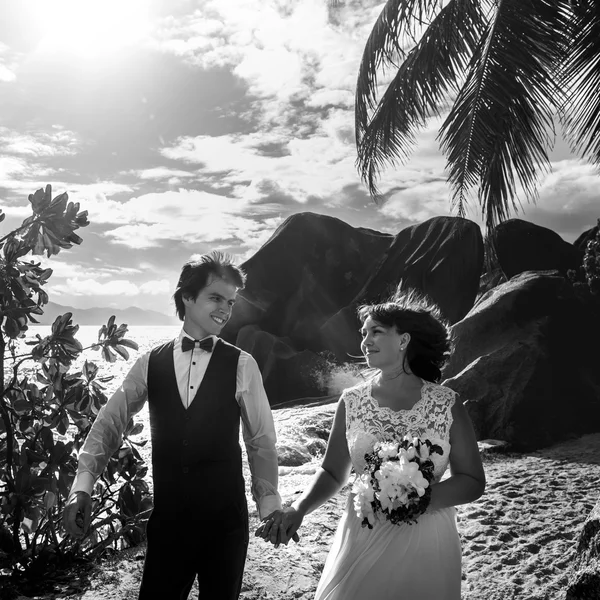 Gelin ve damat sahilde yürüyor.