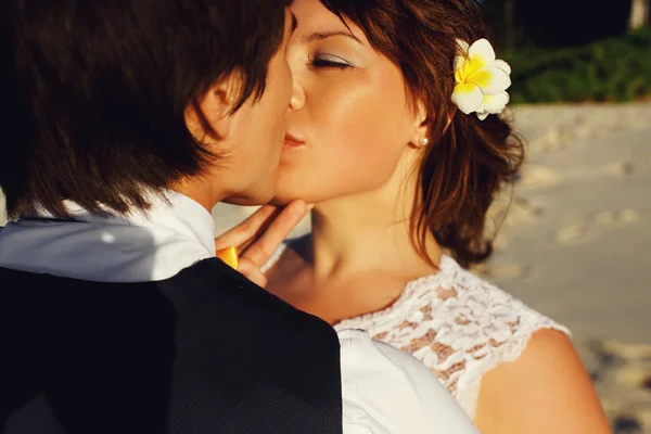 Mariée et marié baisers dans le coucher du soleil — Photo