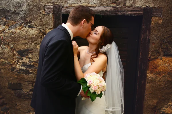 Brudgummen och bruden kysser — Stockfoto