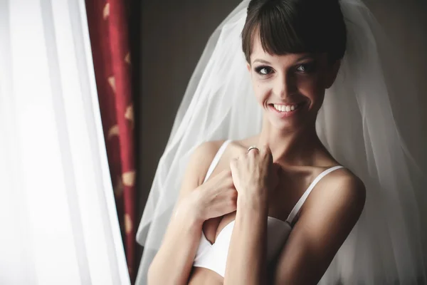 Sonriente novia está posando en la blancura —  Fotos de Stock