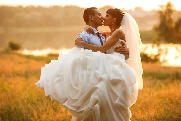 Noivo está segurando e beijando sua noiva — Fotografia de Stock