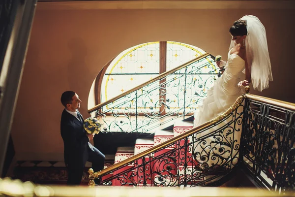 Noivo e noiva nas escadas de fundo — Fotografia de Stock