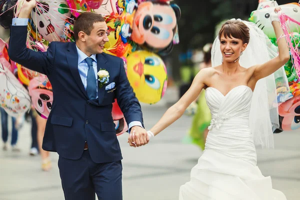 Sorridente coppia che tiene palloncini — Foto Stock