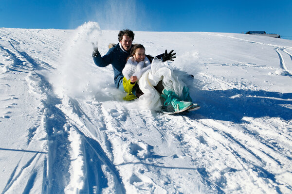 bride and groom in love sledding