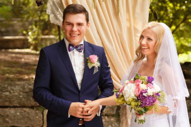 Gelin ve damat el ele tutuşuyorlar.