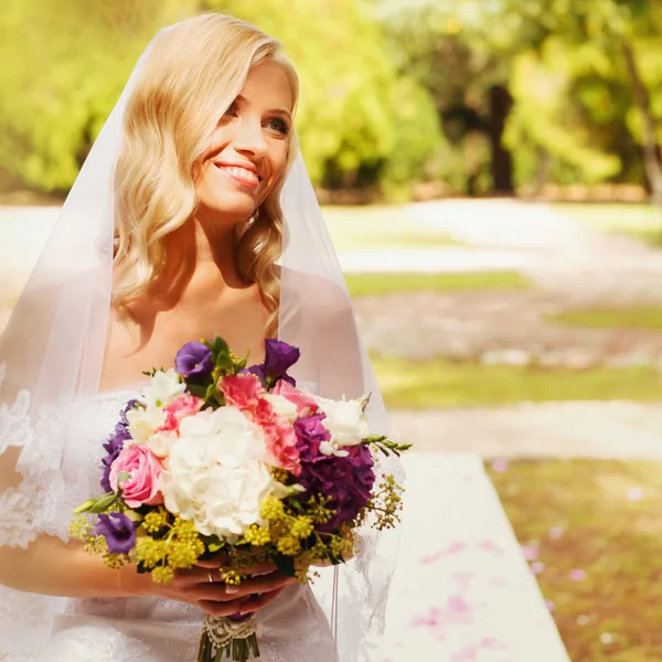 Bruden i trädgården med bukett av flovers — Stockfoto