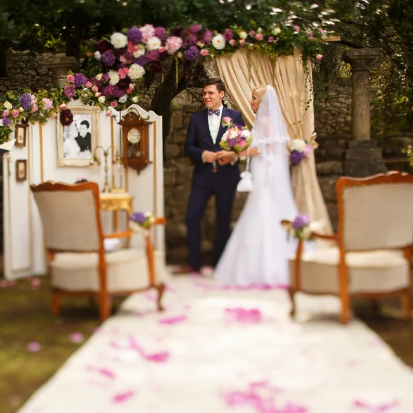 Bride and groom holding hands at a — Stock Photo, Image