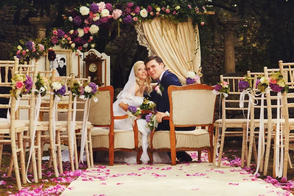 Невеста и жених сидят на стульях — стоковое фото
