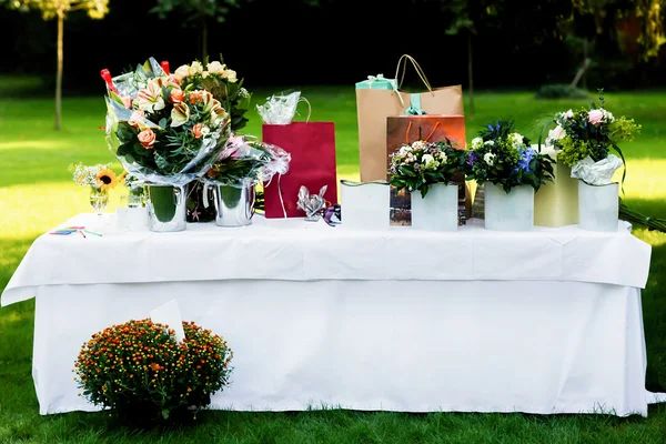 Large white table with flowers — Stock Photo, Image