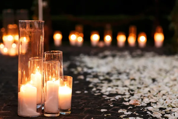 Проход с белыми свечами и лепестками — стоковое фото