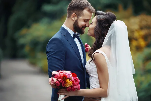 Handsome groom hugging beautiful bride — Stock Photo, Image